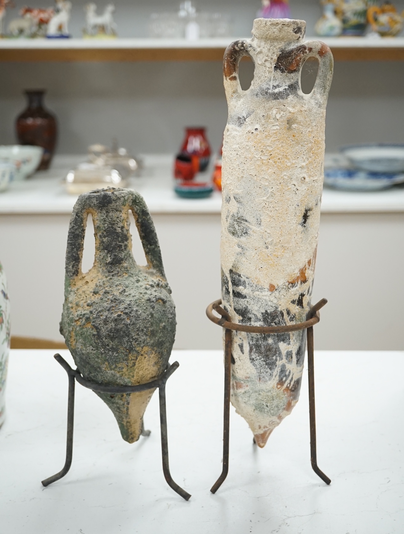 Two pottery amphora on metal stands, tallest 43cm high. Condition - as on line images